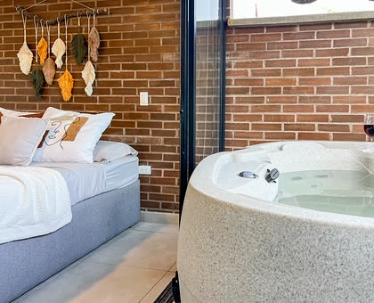 Alcoba con jacuzzi privado y muro en ladrillo a la vista