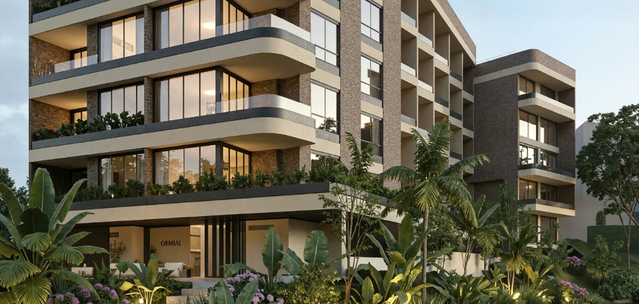 Fachada iluminada de Barlovento Living al anochecer, desde el acceso