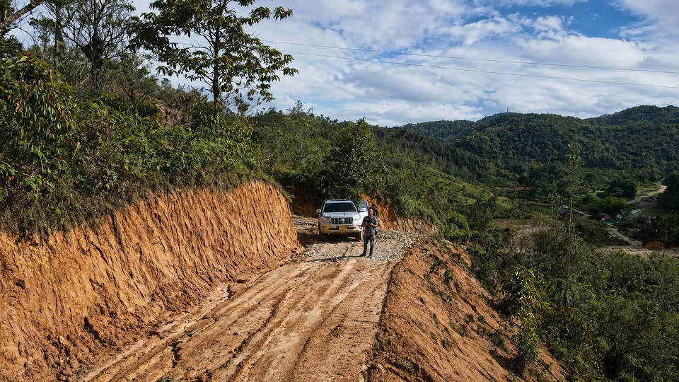 Camioneta y persona sobre el camino de acceso abierto en la ladera