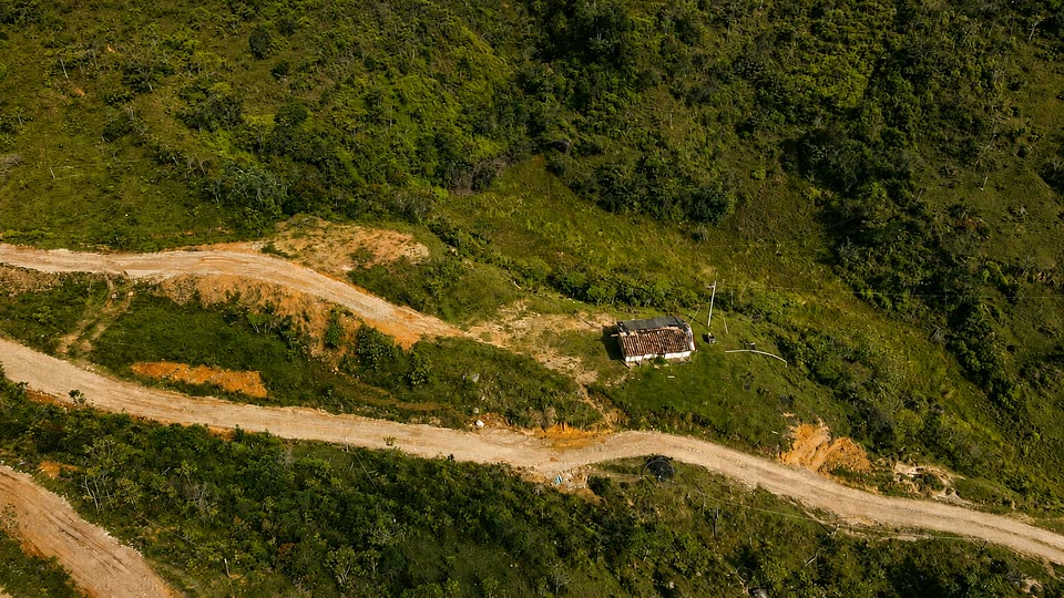 Camino abierto en la ladera de Santa Rita, con una casa aislada
